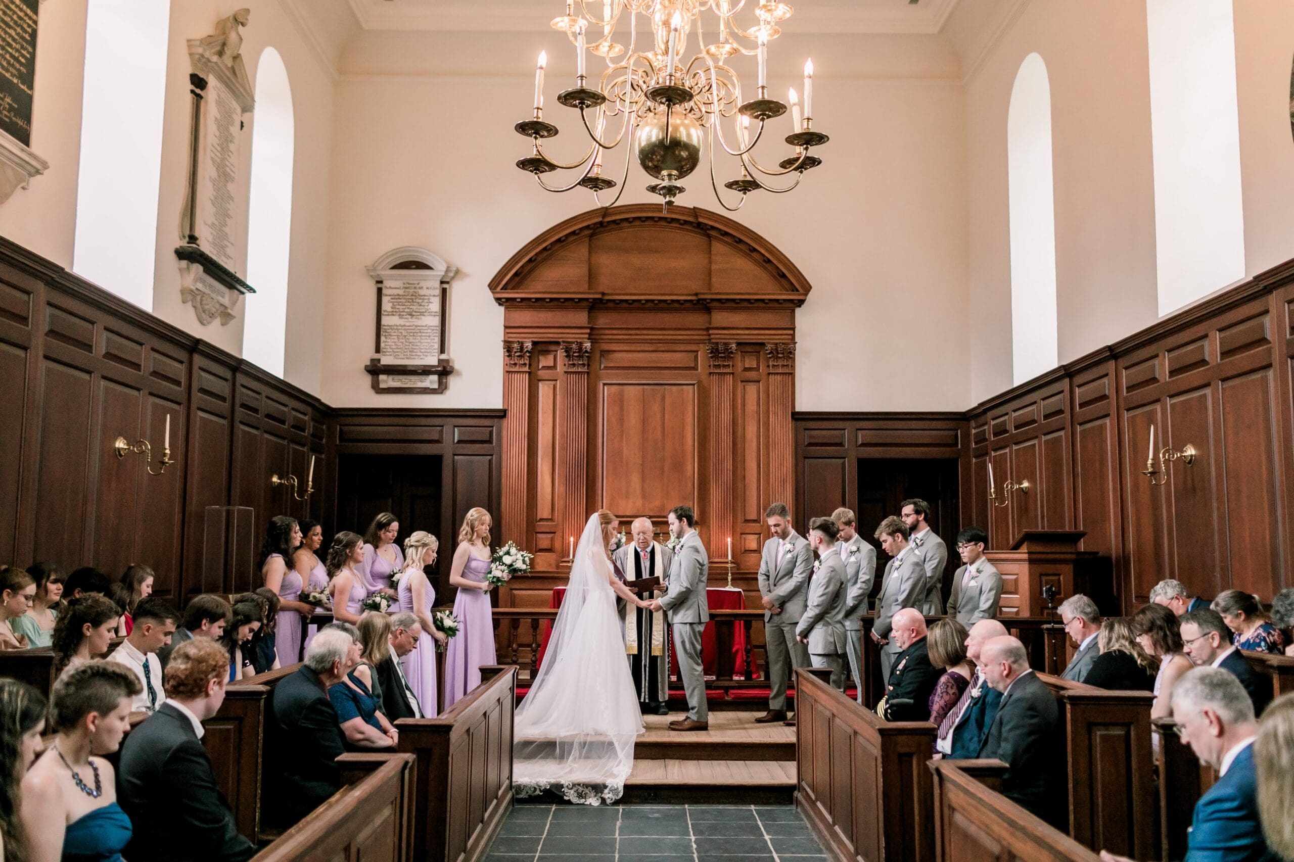 Bride and groom exchanging vows in the historic Wren Chapel, surrounded by elegant colonial architecture and soft natural light, capturing an intimate and timeless moment of love